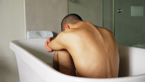hombre sentado en la bañera en el baño 4k