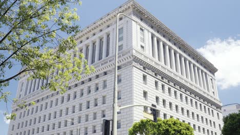 view onto the hall of justice in los angeles california usa during summer time - no camera movement, steady frame with wind in tree leafes