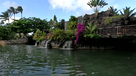 tranquil tropical waterfall and lush garden with wooden bridge