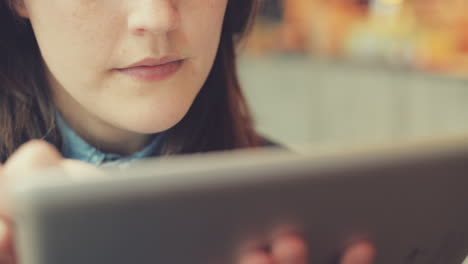 woman using tablet computer touchscreen in cafe