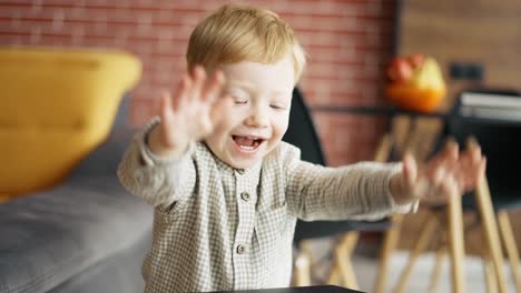 excited blond happy little toddler boy indoors