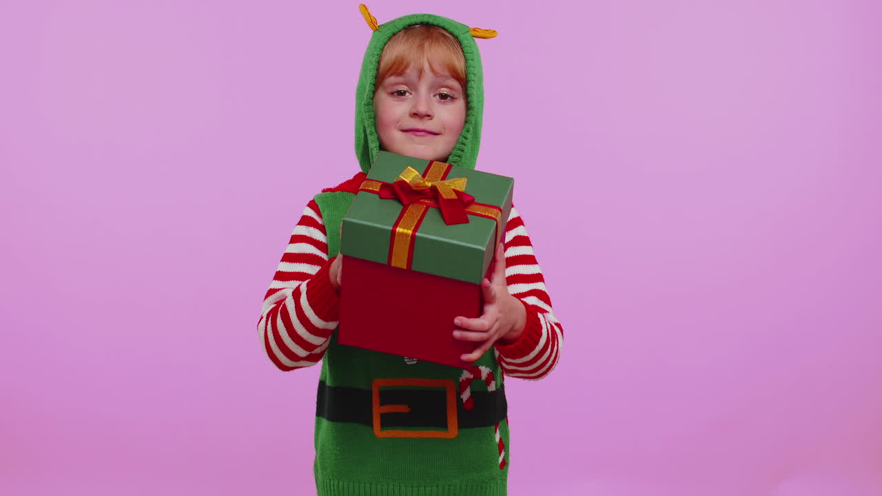Vtipná holčička v kostýmu Santy představující vánoční dárek, nákupní výprodej.