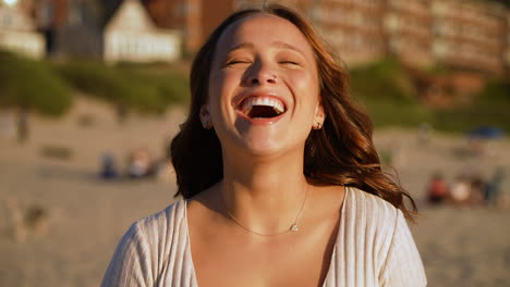 Toma-En-Cámara-Lenta-De-Una-Hermosa-Mujer-Sonriendo-Y-Riendo-En-La-Playa-Al-Atardecer