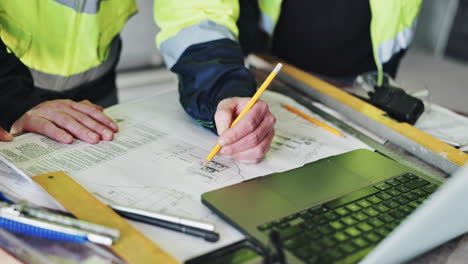 trabajadores de la construcción que revisan los planes