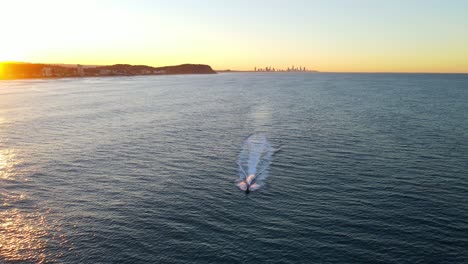 jet skiing in pacific ocean during golden sunrise