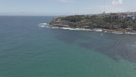 Mar-Azul-En-Calma-Con-La-Península-De-Mackenzies-Point-En-El-Fondo-En-Tamarama,-Nsw,-Australia