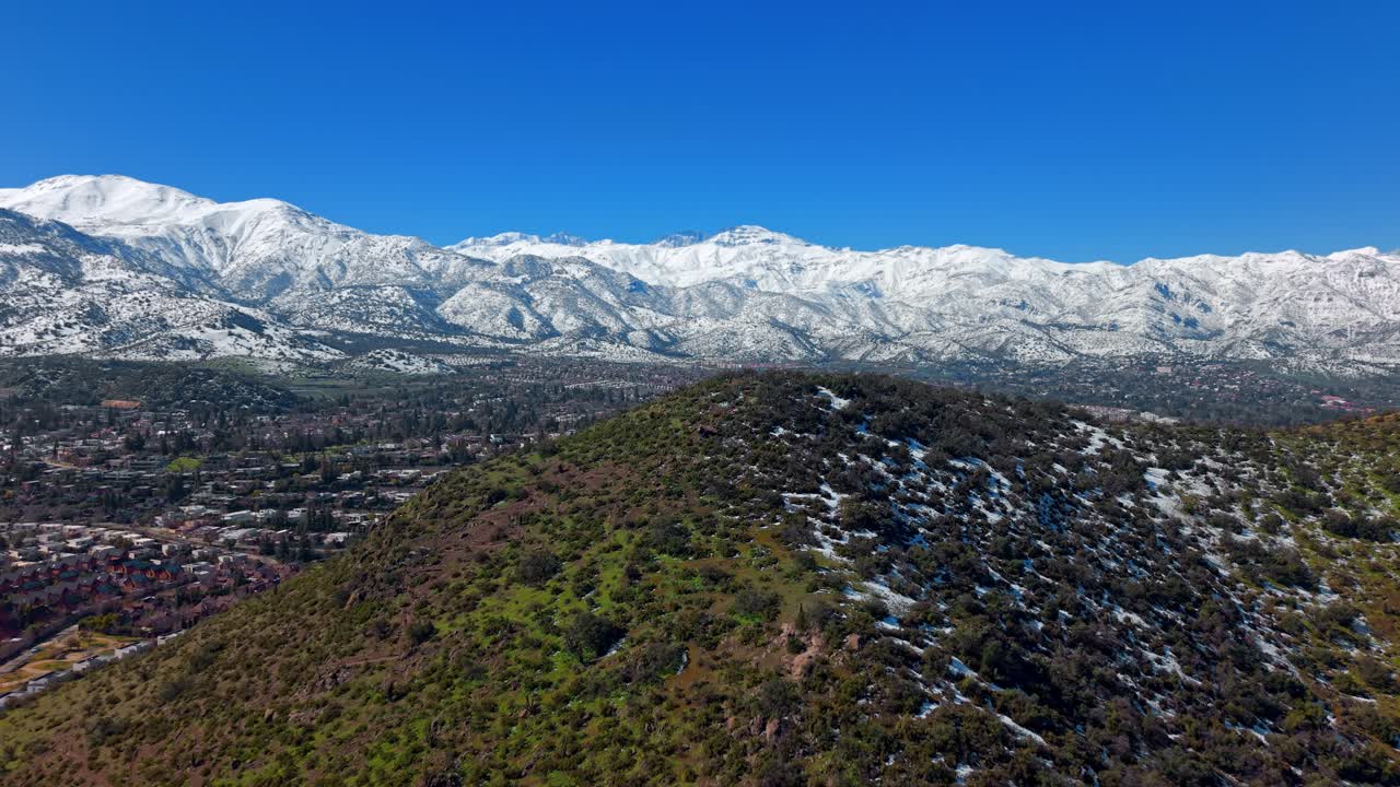 Bird's-eye view from the top of Medio hill, a recreational area in the city of Santiago, Lo Barnechea district, an exclusive neighborhood with the snow-capped Andes Mountains in the background