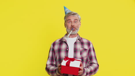 happy mature man surprise gift moment party cone hat joyful shock red bow birthday excitement