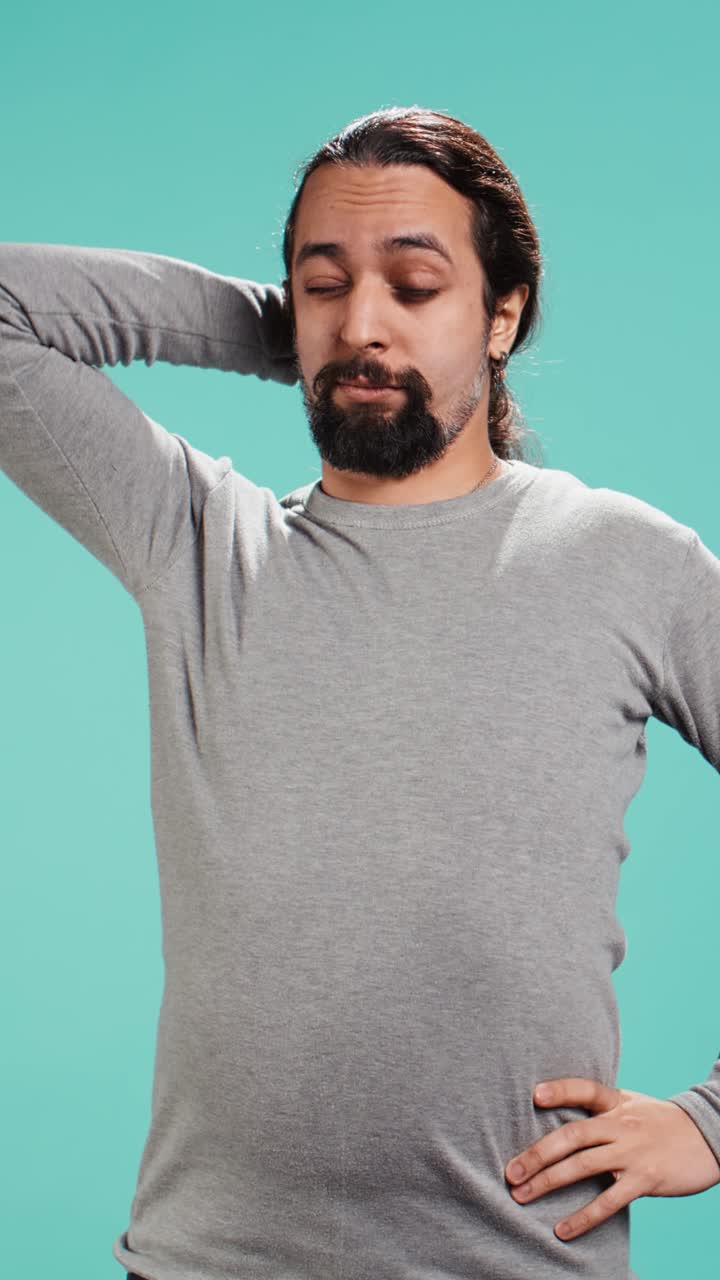 Vídeo vertical de un hombre con aspecto cansado que bosteza y se tapa la boca