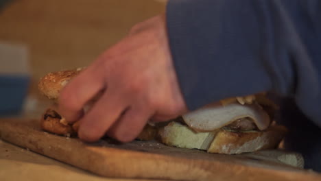 woman cuts homemade burger on a wooden board