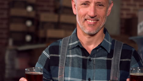trabajador feliz de la cervecería sosteniendo dos pintas