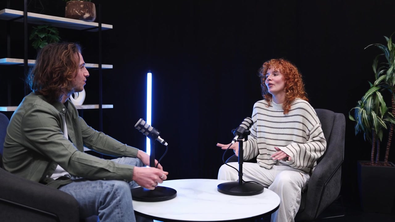 To unge voksne optager et podcastinterview i et moderne studie