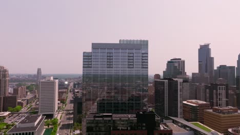un drone push-in captura un gran edificio de vidrio en el centro de minneapolis, mostrando su arquitectura moderna y sus alrededores urbanos