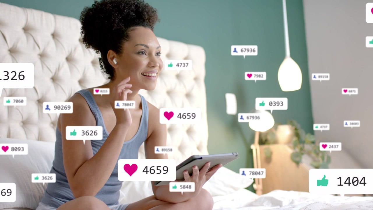 Woman tapping tablet on bed, sparking hearts, likes and followers, cheering social media growth