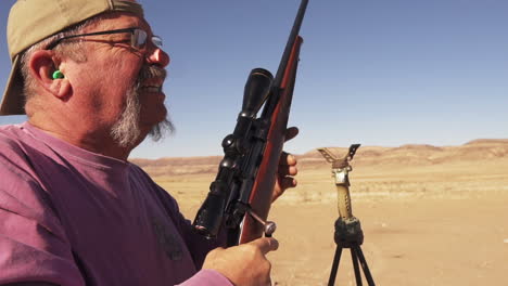 senior man practicing shooting with a rifle using scope and reloading gun