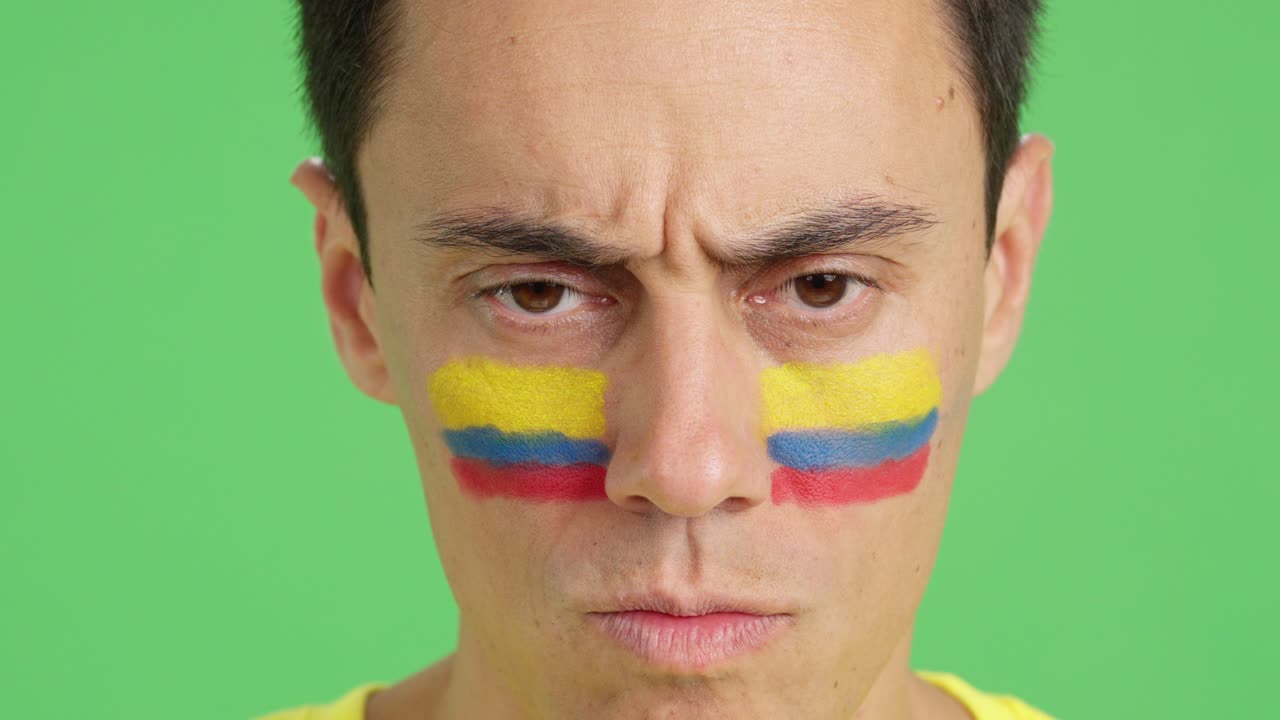 Serious man with a colombian flag painted on the face
