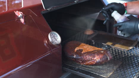 BBQ-Brisket-being-checked-and-sprayed-down-with-a-liquid-butter-mix