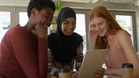 young adult female friends hanging out in a cafe