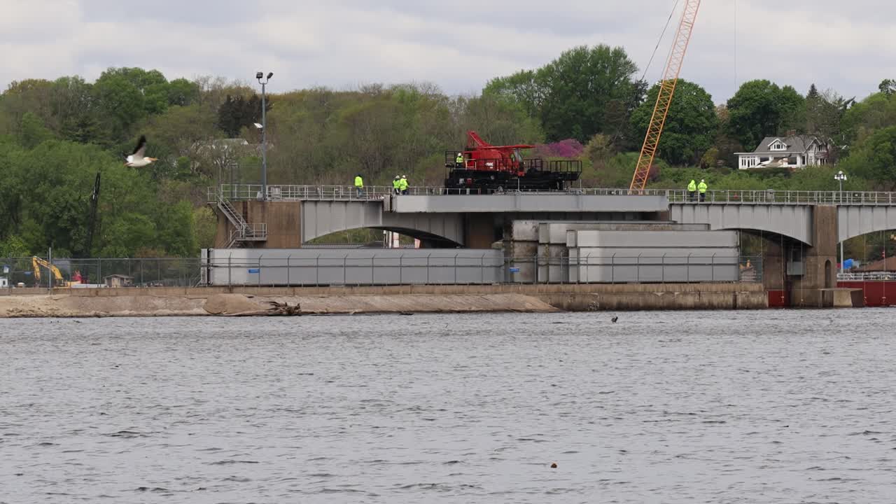 leclair iowa 근처의 미시시피 강에서 자물쇠와 댐 번호 14의 댐 롤러를 수리하기 위해 전문 크레인을 작동하는 소규모 승무원