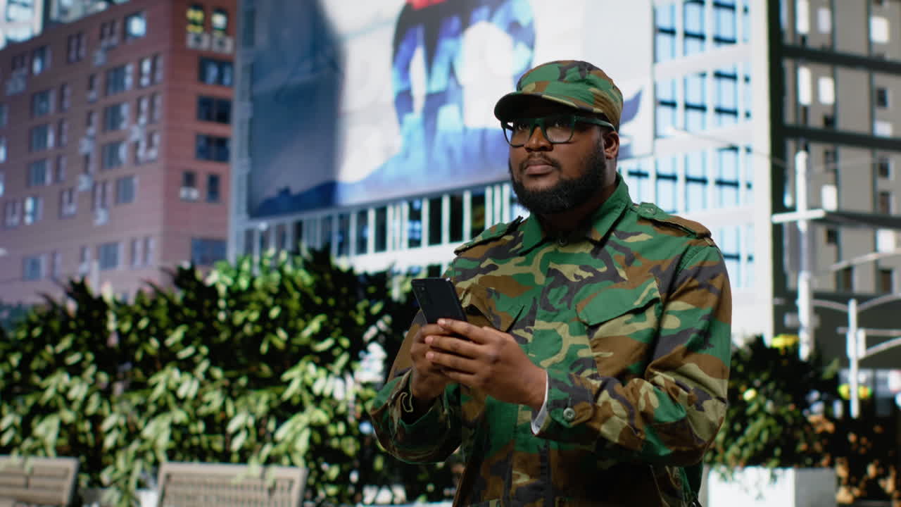African american service person in full gear opens mobile phone map