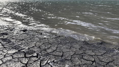 Der-Rissige-Boden-Kontrastiert-Mit-Dem-Reichlichen-Wasser-Am-Ufer-Des-Klöntalersees-Im-Kanton-Glarus,-Schweiz