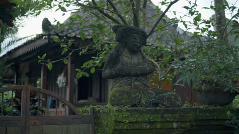 traditional balinese stone figure covered with moss in ubud, bali, indonesia