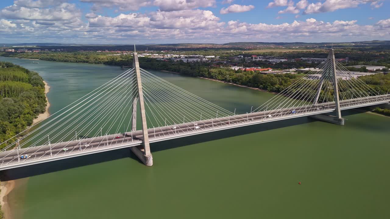 Megyeri Bridge, carrying the M0 ring road across the Danube River in Budapest, Hungary, as cars and trucks move along the modern cable-stayed structure from a drone perspective