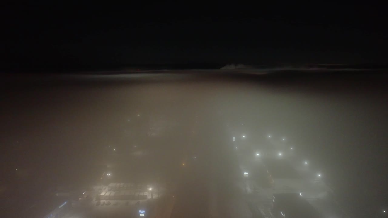 Hazy street in St-Constant, Quebec, Canada with views of snow covered buildings at night time