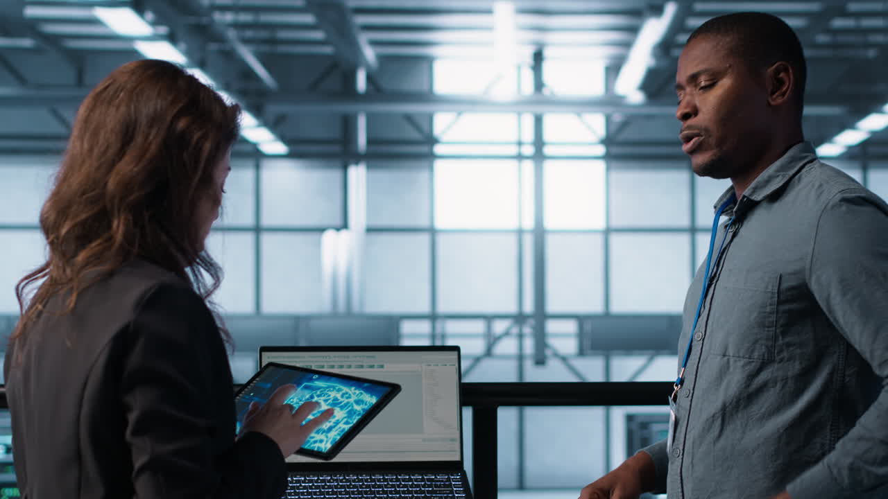Server room coworkers using artificial intelligence on laptop and tablet
