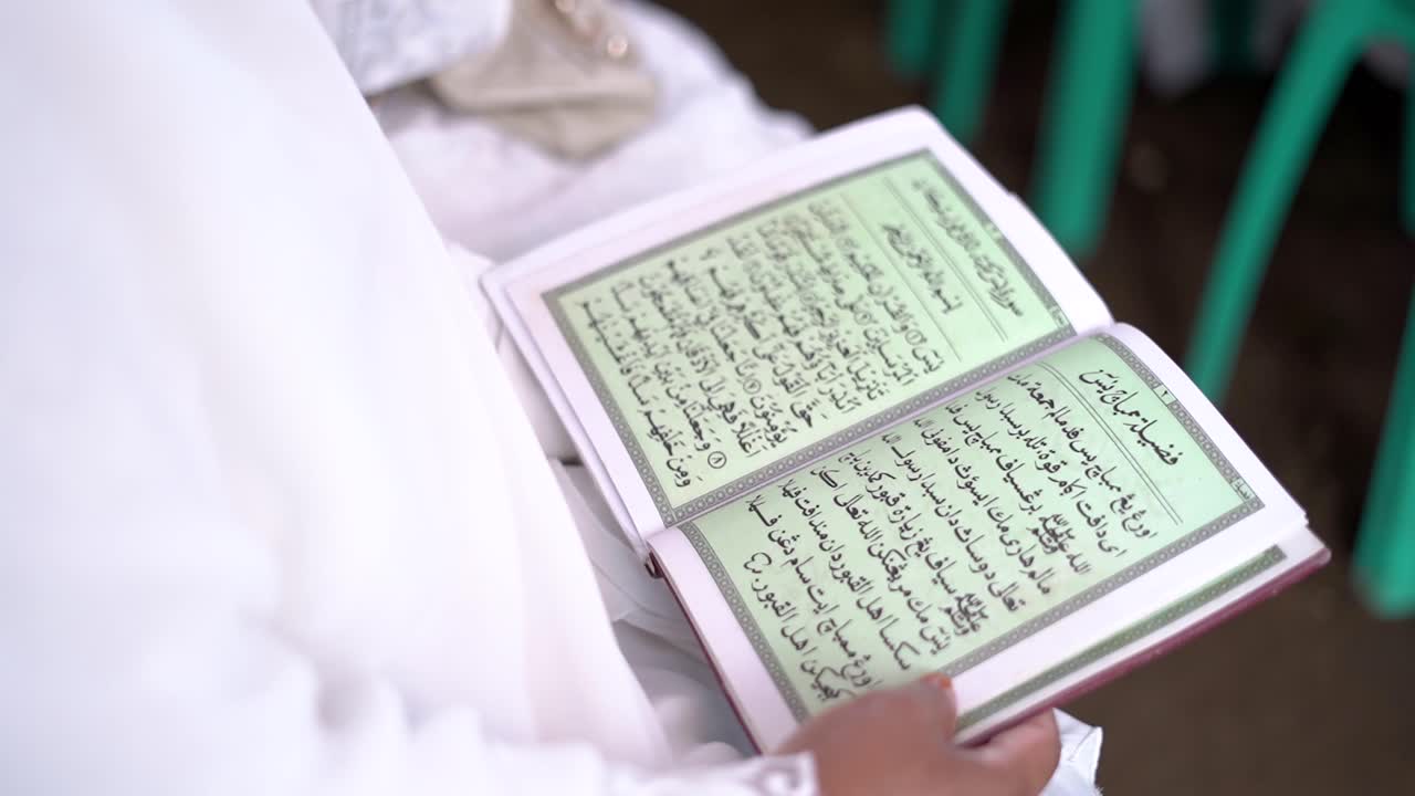 Woman reading Koran with focus on famous verse.