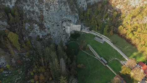 Toma-Aérea-Inclinada-Hacia-Abajo-Del-Castillo-De-Predjama,-Eslovenia