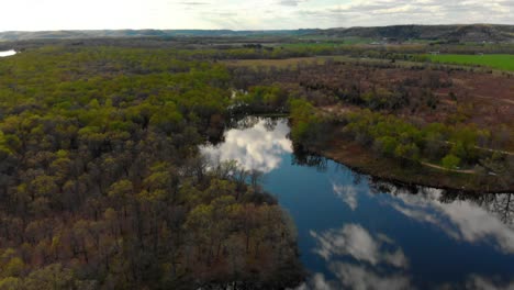 aerial reveal of a sunset overlooking a river with epic reflection off the water