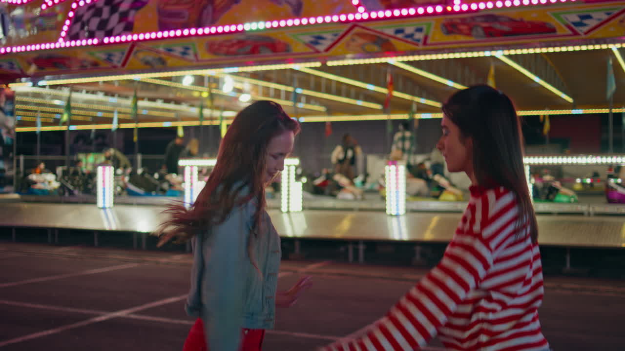 Happy teenagers dancing evening luna amusement park. Excited friends having fun