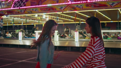 los adolescentes felices bailando por la noche en el parque de atracciones luna. amigos emocionados divirtiéndose.