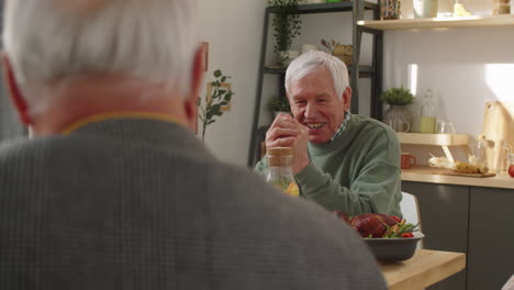 Positive-Senior-Friends-Talking-at-Dinner-Table