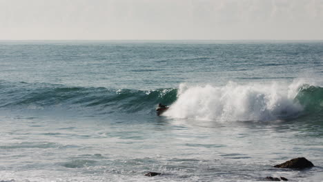 Ein-Bodyboarder-Fängt-Eine-Welle-Und-Zieht-Aus,-Bevor-Er-In-Einen-Flachen-Teil-Der-Küstenbrecherwellen-Geht