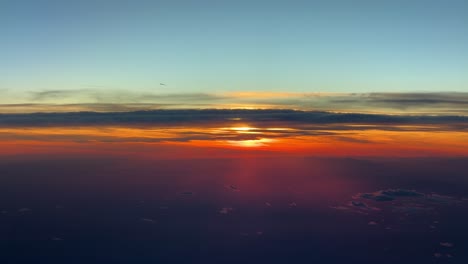 an unique red sunsert from above, recorded from an airplane flying westbound at 12000m high