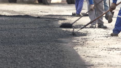 Telephoto-shot-of-a-road-construction-crew-spreading-fresh-gravel-on-a-road