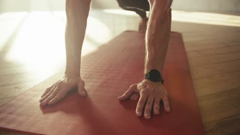 Close-up-shot-of-a-man's-hands-doing-push-ups-on-a-special-red-rug.-Tired-sweaty-hands-of-athletes-on-which-veins-are-visible