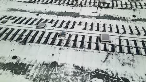 drone shot of solar panels on a industrial building roof covered with snow in winter