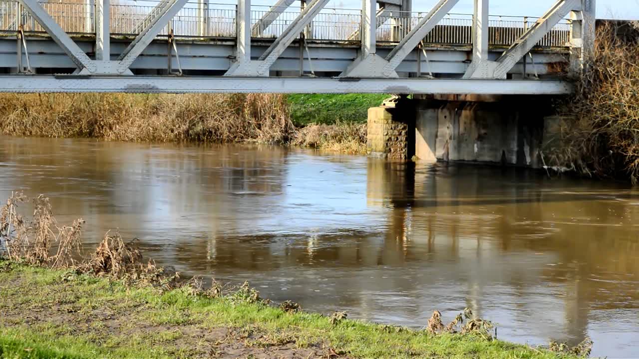 River Don South Yorkshire UK filmed under the A614 bridge as it crosses the river and showing how high and fast flowing the river is.