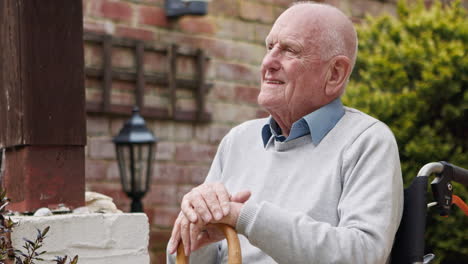 elderly man smiling in a wheelchair outdoors