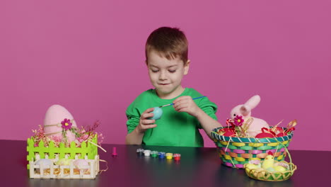 Un-Niño-Alegre-Elaborando-Adornos-De-Pascua-Hechos-A-Mano-Pintando