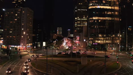 Forwards-fly-above-busy-street-and-multilane-roundabout-in-night-city.-Evening-in-downtown.-Warsaw,-Poland