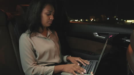 woman working on laptop at backseat