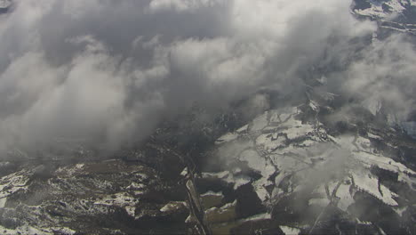 disparo aéreo sobre las nubes mirando hacia abajo en el paisaje cubierto de nieve debajo