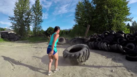 fit woman exercising with huge tyre 4k