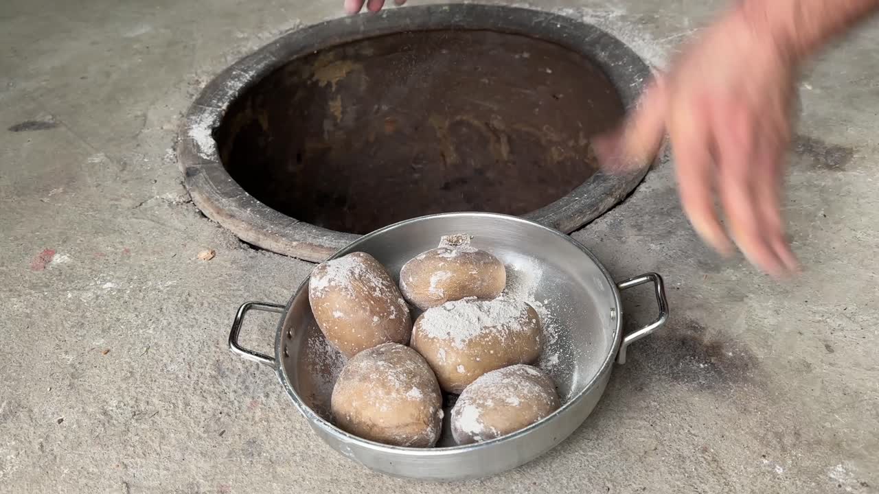quitar la patata cocida naturalmente viejo horno tradicional de arcilla molida que quemó carbón leña leña hueso fuego de campamento fuego horneado lentamente concepto de comida saludable frito patata crujiente con piel crujiente en la sartén