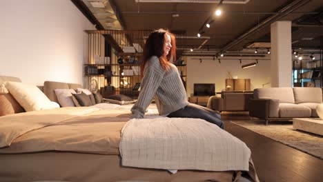 a woman in a furniture store looking at a bed