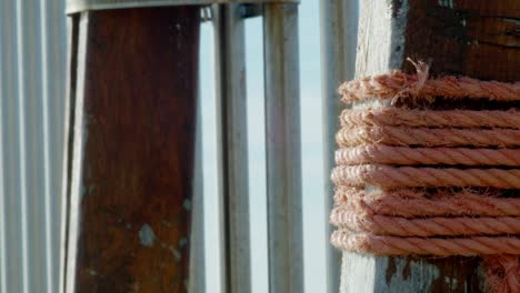 orange rope tied around old varnished wood.